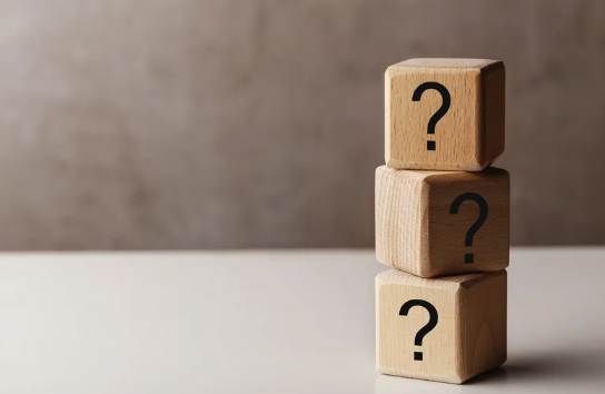 a stack of wooden blocks with question marks on them